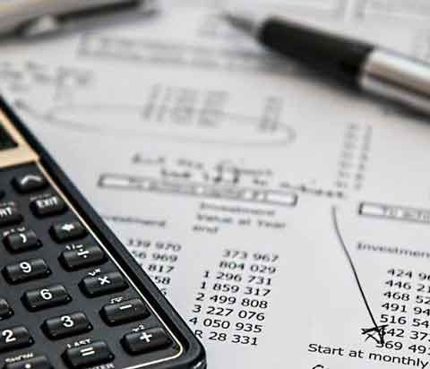 calculadora con papeles en mesa