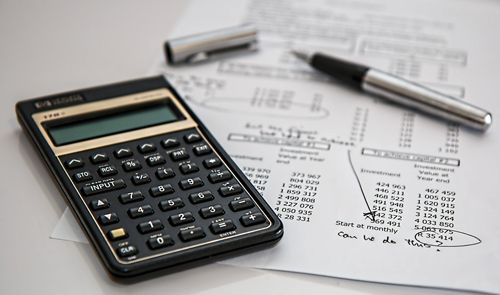 calculadora con papeles en mesa